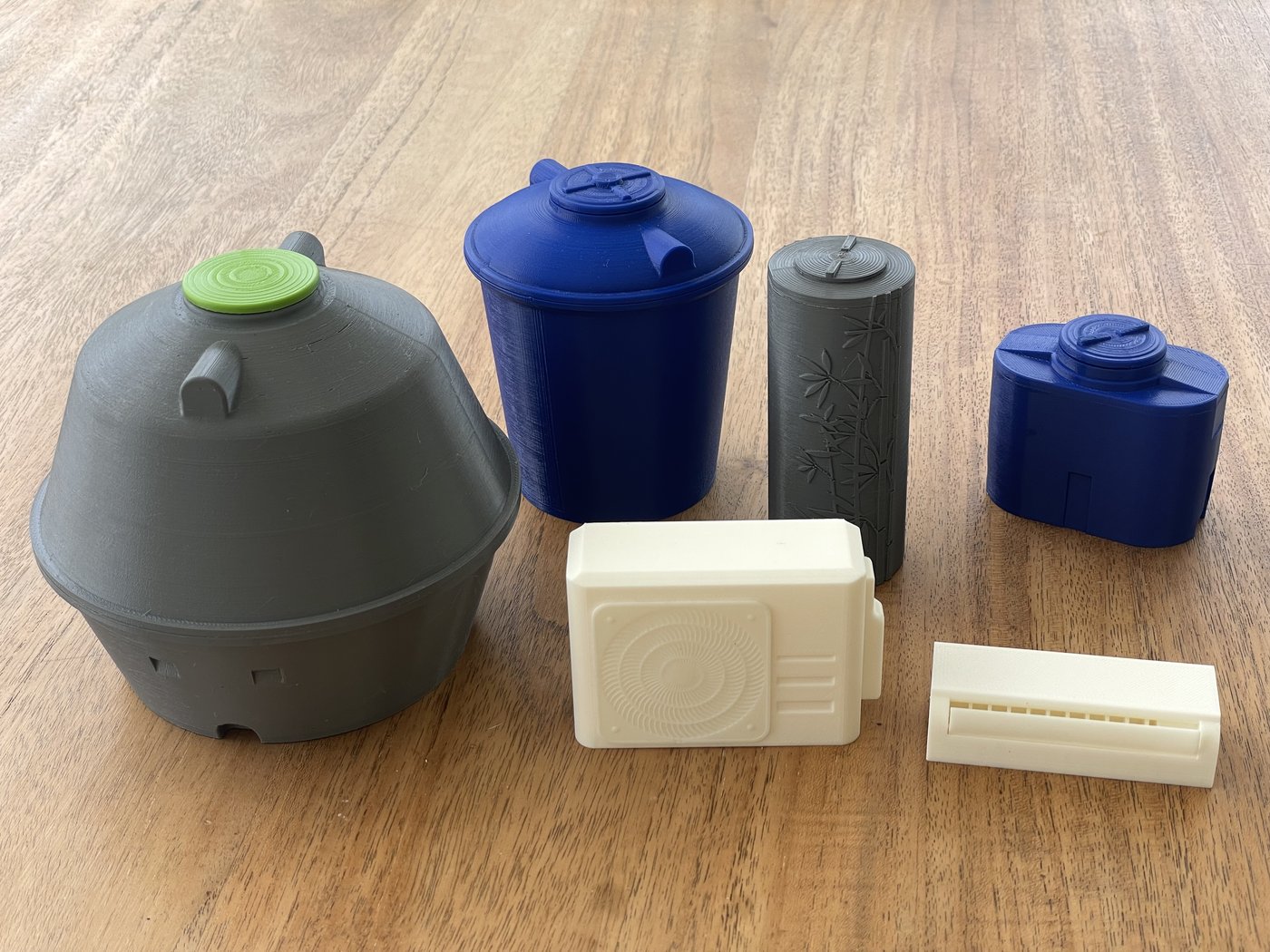 Plusieurs petits objets imprimés en 3D : boîtes, capuchons, pot